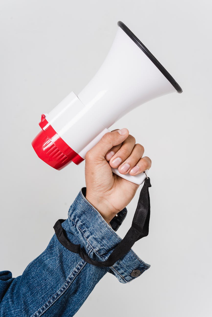 man in blue denim jacket holding a megaphone